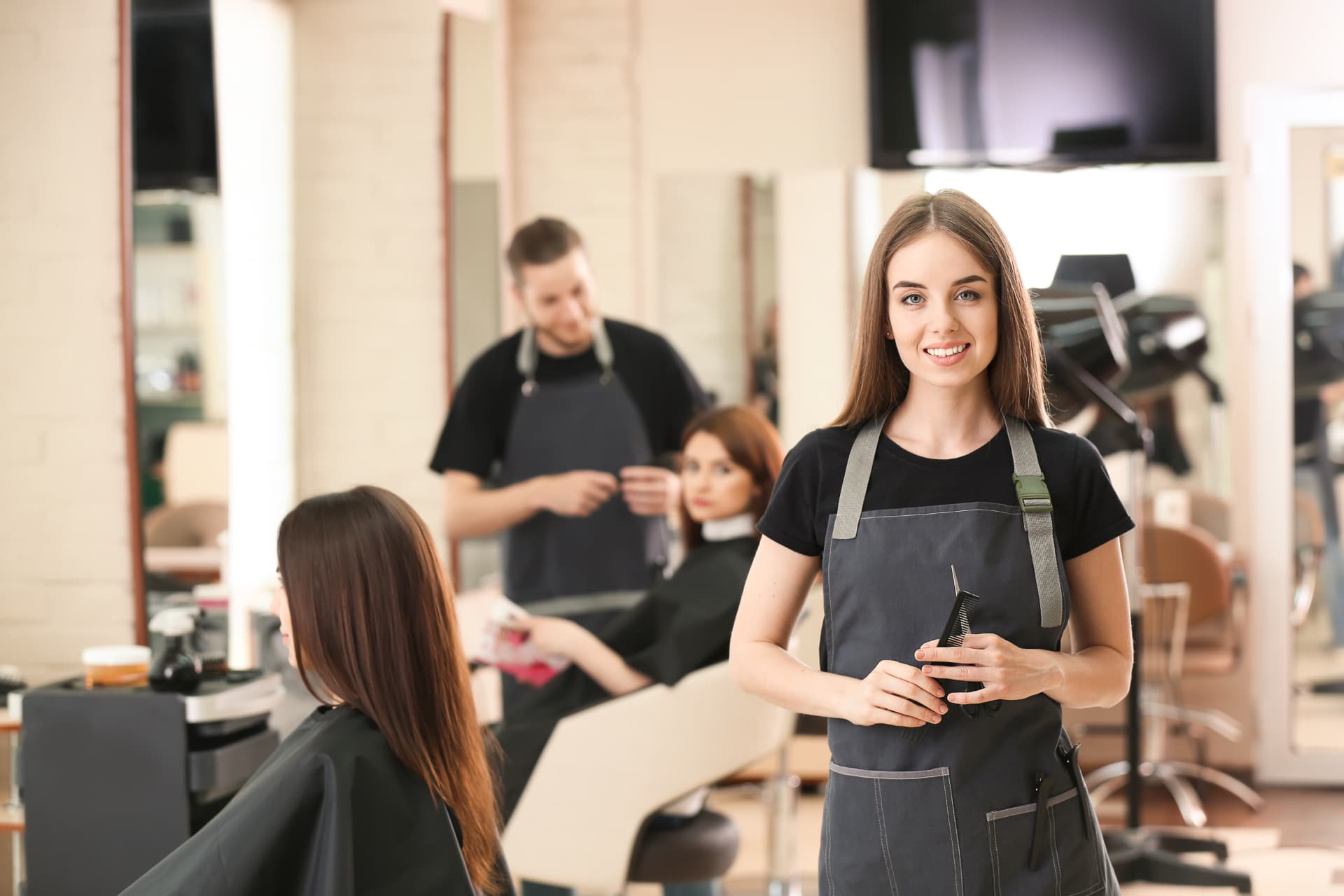 An independent stylist in her apron, ready for clients in a working salon