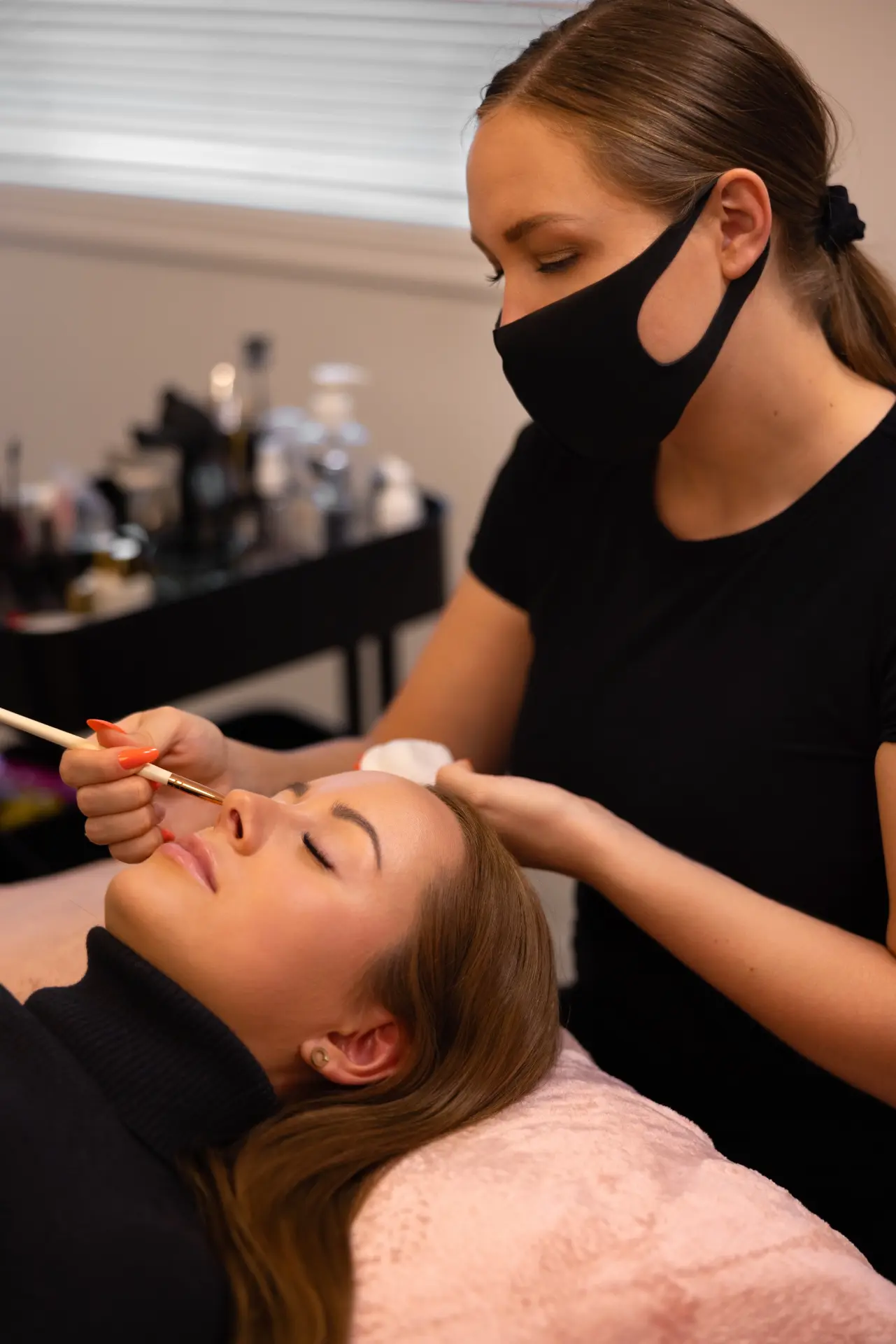 Beauty professional working with a reclined client in a private treatment space